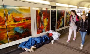 People walking past a homeless person sleeping, London