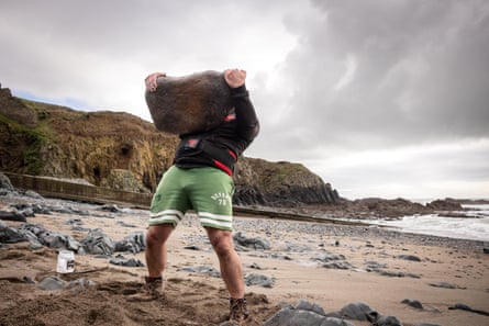 Keohan lifting a stone on the beach