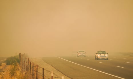 Cars drive through smoke as firefighters battle blazes on Wednesday in Vacaville, California. 