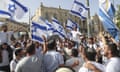 A large group of men gathered in the street holding up Israeli flags