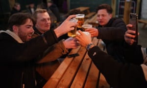 Friends make a toast as they enjoy a drink at the Switch bar in Newcastle shortly after midnight following the easing of lockdown measures on April 12, 2021 in Newcastle Upon Tyne, England.