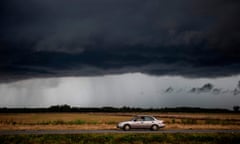 US-WEATHER<br>A car drives under an ominous rain cloud from tropical storm Marco as locals prepare for the arrival of hurricane Laura near Lake Charles, Louisiana on August 25, 2020. - Storm Laura was upgraded to a destructive hurricane on August 25 and is forecast to make landfall along the Texas or Louisiana coasts on Wednesday night, after earlier causing 20 deaths in Haiti.”Laura has become a hurricane with maximum sustained winds of 75 mph (120 km/h), with higher gusts,” the US National Hurricane Center reported. (Photo by Andrew CABALLERO-REYNOLDS / AFP) (Photo by ANDREW CABALLERO-REYNOLDS/AFP via Getty Images)