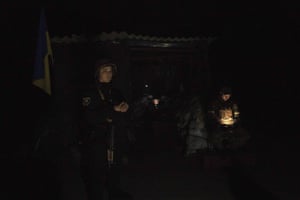 Ukrainian servicemen stand guard at a check point during the night time curfew in Donetsk