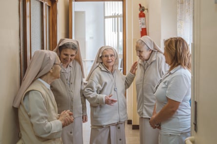 Nuns laughing in a corridor.