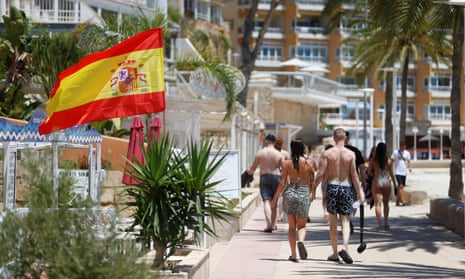 Tourists walk by the seafront at Magaluf beach, Mallorca