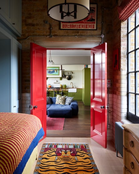 Double doors painted reddish framework the surviving room, with the greenish room beyond