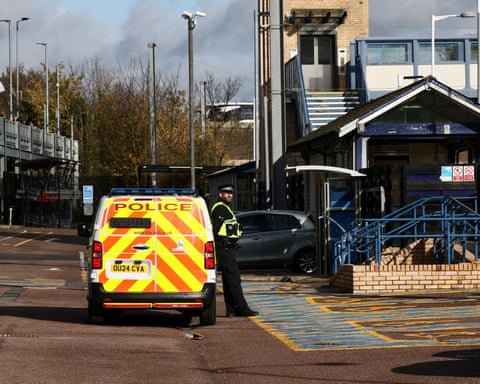 A police officer stands next to a police vehicle at Huntingdon station