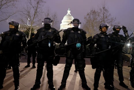 Police officers in riot gear line up near the Capitol building in Washington DC. 