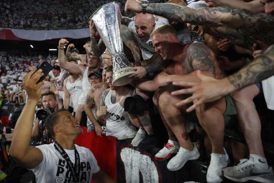 Eintracht Frankfurt’s Timothy Chandler lets fans hold the trophy as they celebrate winning the Europa League.