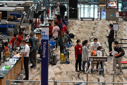 Travellers at a check-in counter at Changi airport in Singapore