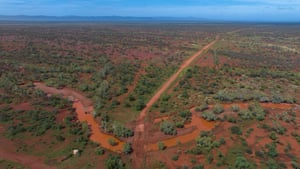 A creek cuts through the scrub and red earth