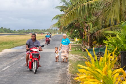 Local people on a road that runs along the side of the airport runway, in central Funafuti