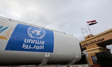 A container with a blue sticker on it with the UN logo and the letters 'UNRWA' written on it in white