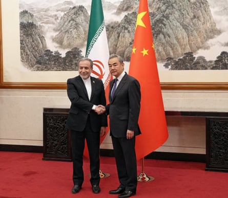 Wang Yi and Iranian Abbas Araqchi shake hands in front of flags