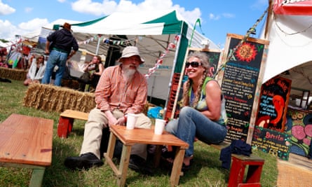 A couple sit dining at outside bench seats at the Shambala festival, 2015, in Northamptonshire.