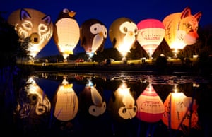 Isle of Wight, UK: Balloons light up as they are tethered to the ground during the night glow at the Isle of Wight Balloon Festival at Robin Hill Country Park