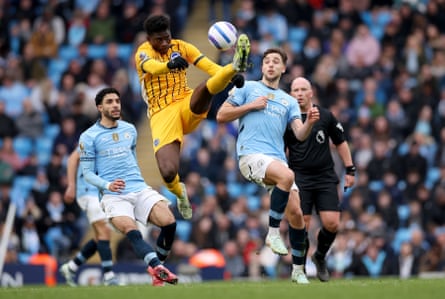 Carlos Baleba of Brighton hooks the ball away from Nico Gonzales and Omar Marmoush of Manchester City at the Etihad Stadium