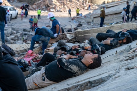 Rescuers and volunteers rest on the rubble of collapsed buildings in Caraballeda, La Guaira state, on 28 June.