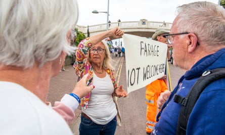 Finger-pointing as an anti-Farage protester brandishes a banner in Clacton.