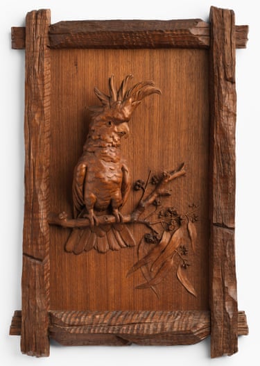 A wood carving of a cockatoo perched on a gum branch