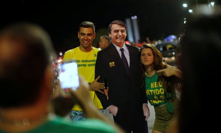 Supporters of Jair Bolsonaro pose with a cardboard cutout of him in Brasilia.