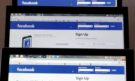 Computer screens display the Facebook sign-in screen