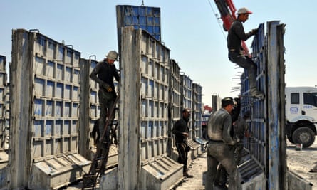 Turkish workers with some of the modular blocks that will form the wall along the Syrian border