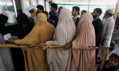 Burqa-clad women wait to cross the Afghanistan-Pakistan land border at Torkham, Pakistan, in September.