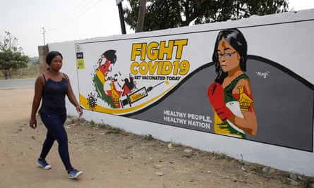 A woman walks past a mural encouraging people to get vaccinated against Covid-19 in Epworth, Harare, Zimbabwe, August 2021