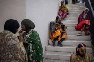 Young women in traditional attire sitting on steps