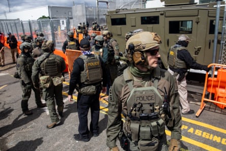 men in tactical gear stand on a road