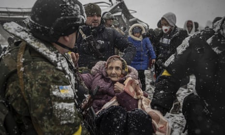 Officers evacuate an elderly woman as civilians continue to flee from Irpin due to ongoing Russian attacks.