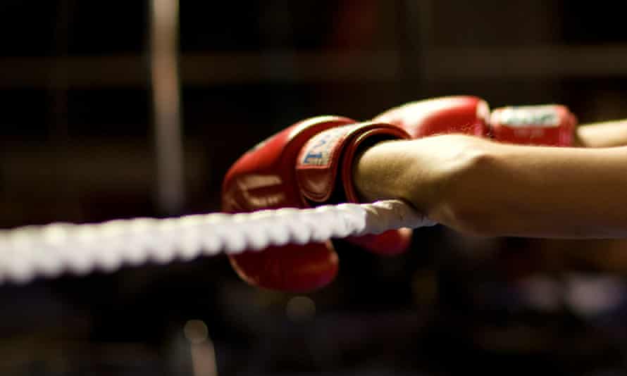 Boxer's gloved hands on a rope