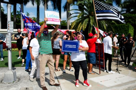 people hold signs in support of Donald Trump outside