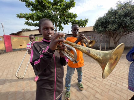 A boy plays a trumpet in Homeland Brass Band Kampala, Uganda