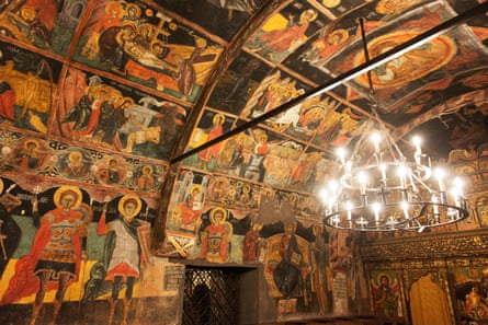 Art and a chandelier inside an old church in Bulgaria.