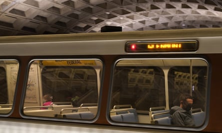 A passenger wearing a face mask sits on an otherwise empty train at Metro Center station in Washington DC.