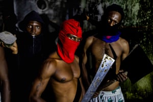 Gang members with faces covered, one holding a machete