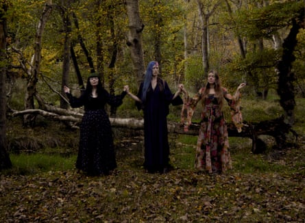Tristwch y Fenywod holding hands in a forest.