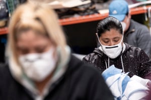 Workers at a sewing shop in Los Angeles wear masks as they make masks for local hospitals.