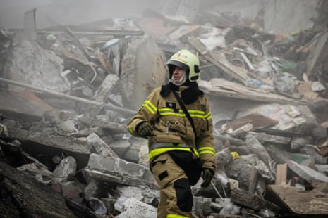 A rescue worker scours the rubble during search and rescue operations at a residential building hit by a missile in Dnipro, Ukraine.