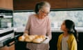 Grandmother and granddaughter baking scones in kitchen<br>Grandmother and granddaughter baking scones together in kitchen