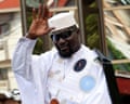 Doumbouya, wearing sunglasses and loose white clothing, waves after submitting his candidacy at the supreme court in November