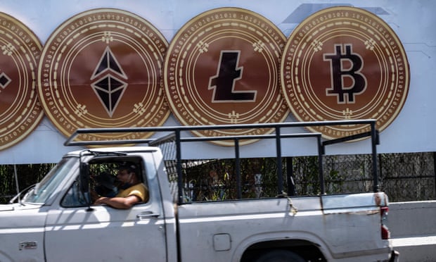 A man drives his vehicle  in front of an advertising sign promoting different virtual currencies including bitcoin