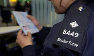 A UK Border Force official checks a passport