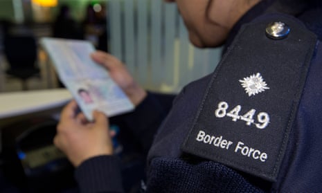 A Border Force officer checking a passport.
