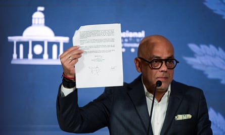 Jorge Rodriguez holds up the document in Caracas on Wednesday.