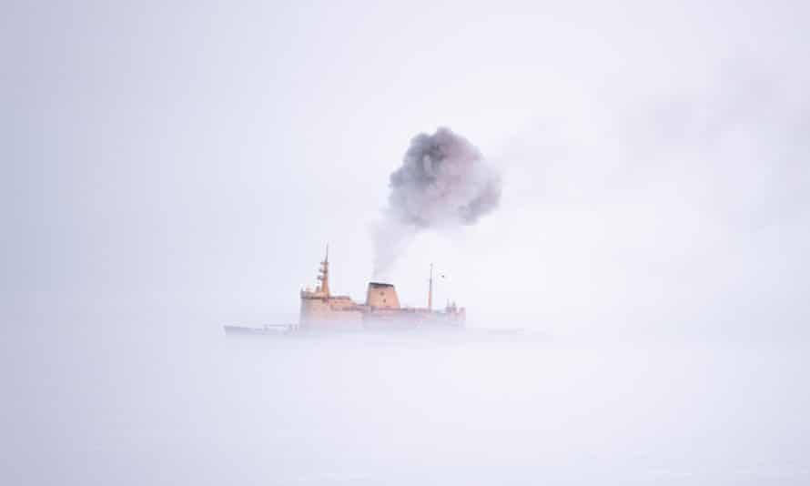 Des gaz d'échappement noirs sont émis par l'entonnoir d'un navire dans le brouillard 