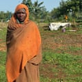 A woman stands in a scrubby landscape