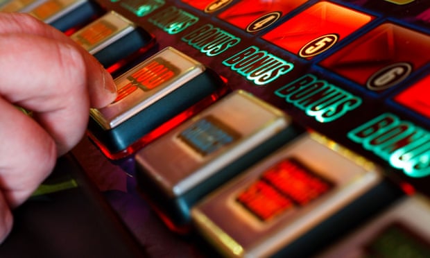 Person presses the hold button on slot machine